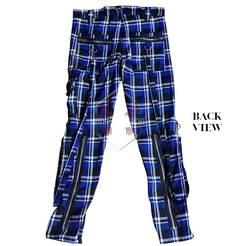 May include: Back view of blue, black, and white plaid pants with multiple zippers and pockets. The pants have a straight leg design and feature silver-colored hardware. The words "BACK VIEW" are printed in black.