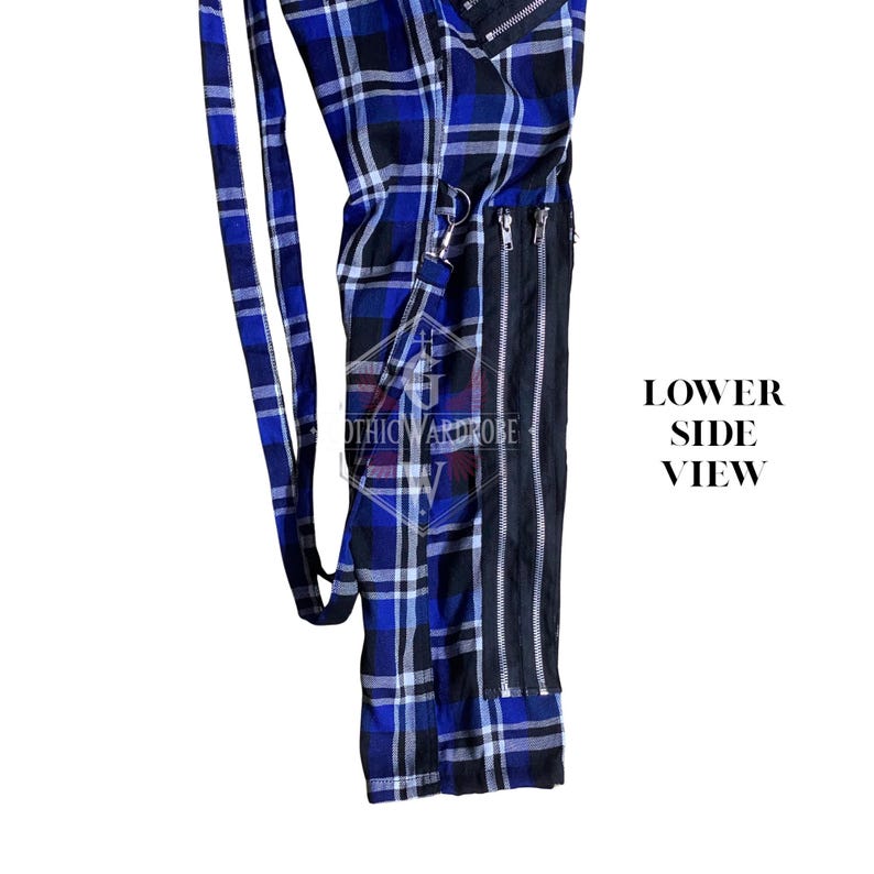 May include: Lower side view of a pair of blue and black plaid pants with a black vertical panel and silver zippers. The pants have a long blue strap and the text "GOTHIC ARDROBE".