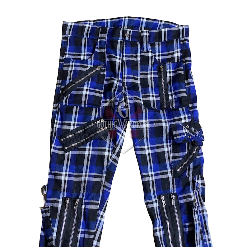 May include: Blue and black plaid pants with multiple black zippers and pockets. The pants feature a classic plaid pattern with a modern, edgy design. The text "GOTHIC WARDROBE" is visible.