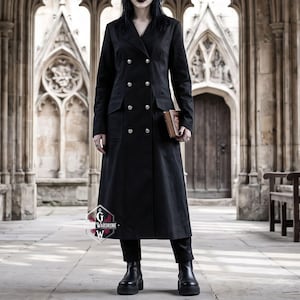 Può includere: Un lungo cappotto nero a doppio petto con bottoni argentati, revers classici e due tasche frontali con patta. Il cappotto arriva a metà polpaccio ed è indossato sopra pantaloni e stivali neri. È visibile un logo con la scritta GOTHIC WARDROBE.