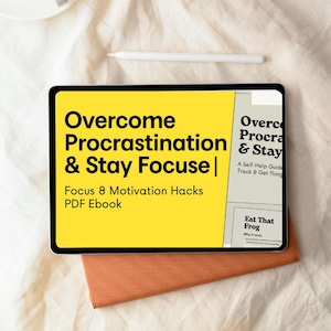 Könnte beinhalten: Ein Tablet zeigt den Titel "Overcome Procrastination & Stay Focus" auf gelbem Hintergrund. Der Text "Focus 8 Motivation Hacks PDF Ebook" ist ebenfalls sichtbar. Ein weißer Stift liegt über dem Tablet, und ein orangefarbenes Tuch liegt darunter.