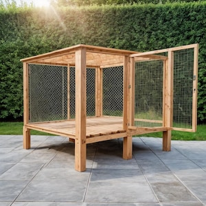 May include: A wooden outdoor enclosure with a slatted floor and wire mesh sides and door. The structure is made of light-colored wood and is set on a patio. The door is open, revealing the interior.