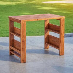 Op de afbeelding: Een rechthoekige houten tafel met een natuurlijke afwerking. De tafel heeft een plat blad en twee planken aan elke kant. Gemaakt van massief hout en geschikt voor buitengebruik. Afmetingen: 102 cm lang, 51 cm breed en 76 cm hoog.