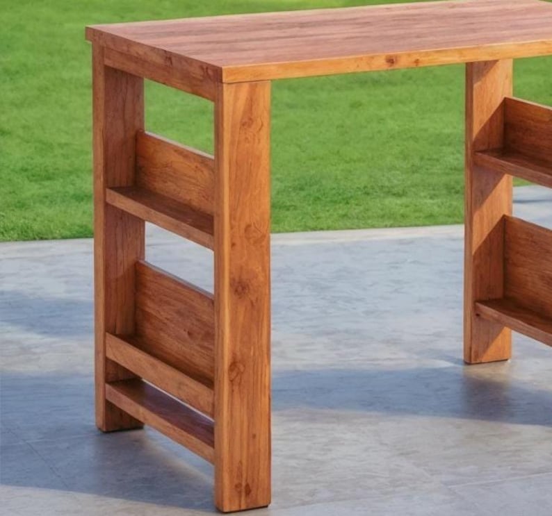 Op de afbeelding: Een houten bartafel met een natuurlijke afwerking. De tafel heeft een rechthoekig blad en een onderste plank aan elke kant. De tafel is gemaakt van massief hout en heeft een eenvoudig, modern ontwerp. De tafel is ongeveer 102 cm lang.