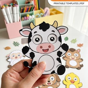 May include: A paper cow cutout with black spots, yellow horns, and large eye sockets for DIY moving eyes. The text DIY MOVING EYES FARM ANIMALS PRINTABLE TEMPLATES | PDF is visible. Other paper farm animals include a sheep, horse, dog, and chick.