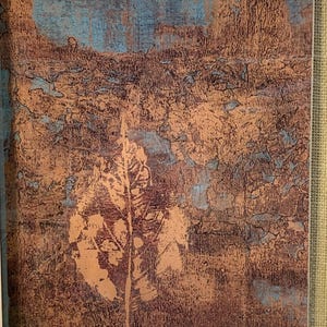 Puede incluir: Impresi&oacute;n art&iacute;stica abstracta con un dise&ntilde;o texturizado en tonos marrones, cobrizos y azules. Una gran huella de hoja est&aacute; centrada en la obra de arte. La impresi&oacute;n est&aacute; enmarcada en un borde blanco.