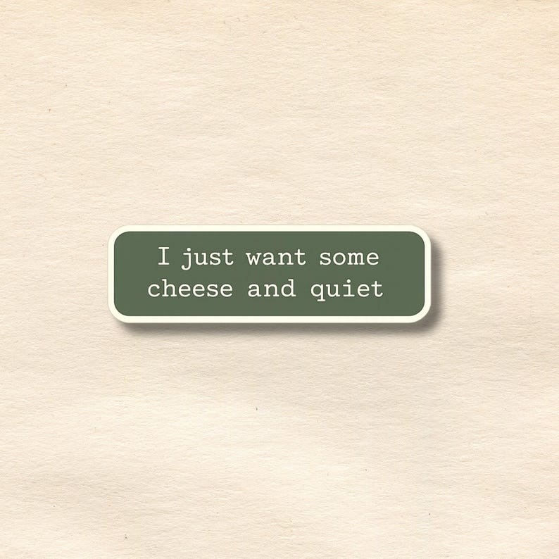 Peut inclure: Un autocollant rectangulaire aux coins arrondis, avec le texte blanc "I just want some cheese and quiet" sur un fond vert fonc&eacute;. L'autocollant a une bordure blanche et est pos&eacute; sur un fond textur&eacute; blanc cass&eacute;.