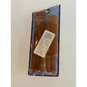 May include: A six-pack of brown combs in a clear plastic package. The package includes pocket combs, purse combs, dressing combs, tail combs, all-purpose combs, and purse-size super combs. The label reads "Family 6 Pack Unbreakable Combs."