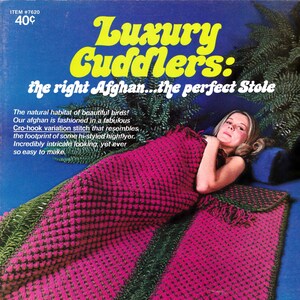 Könnte beinhalten: Vintage-Werbung für eine reversible Afghan-Decke. Die Decke ist leuchtend rosa mit dunkelgrünen Verzierungen und Fransen. Der Text "Luxury Cuddlers" ist in Gelb dargestellt, mit zusätzlichem Text, der die Eigenschaften der Decke beschreibt.