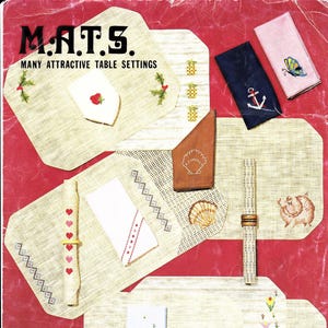 May include: A collection of embroidered table settings, including placemats, napkins, and napkin rings. The placemats are beige with various embroidered designs such as strawberries, pineapples, and holly. Napkins feature embroidered anchors, butterflies, and hearts. The text "M.A.T.S. MANY ATTRACTIVE TABLE SETTINGS" is at the top.