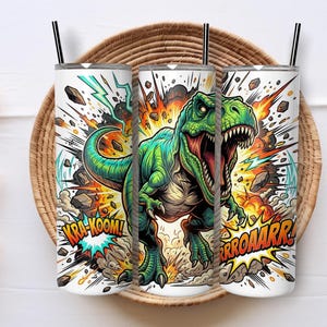Puede incluir: Un vaso cilíndrico con pajita que presenta un gráfico de un tiranosaurio rex verde en medio de una explosión estilo cómic. El diseño incluye el texto KRA-KOOM y RROOAARR en letras amarillas y naranjas sobre un fondo blanco.
