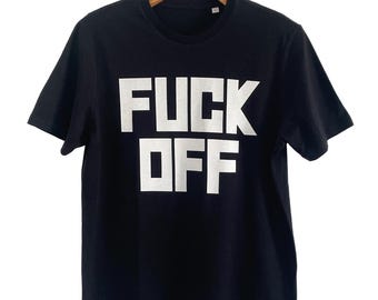 May include: A black short-sleeved t-shirt featuring the text FUCK OFF printed in large, bold, white capital letters across the chest. The garment has a standard crew neckline and is displayed on a wooden hanger against a plain white background.