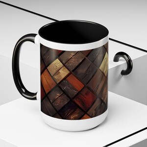 May include: A ceramic mug with a black interior and handle, featuring a white exterior surface decorated with a repeating diagonal grid pattern of various wood grain textures in shades of brown, tan, dark espresso, and light golden oak tones.