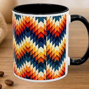 May include: A ceramic mug with a black interior and handle, featuring a repeating geometric chevron pattern in shades of orange, red, dark blue, and cream. The exterior surface displays a vertical arrangement of interlocking arrow shapes.