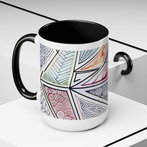 May include: A white ceramic mug with a black handle and the text "But First, Coffee" in a black, bold font. The mug is on a white surface.