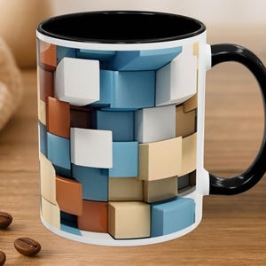 May include: A ceramic mug with a black interior and handle, featuring an exterior pattern of three-dimensional cubes in shades of white, light blue, tan, and brown. The design creates a geometric, layered effect across the surface of the mug.