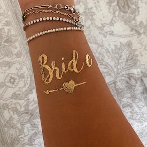 Goldene Team Bride und Bride Tattoos, Tattoos für Junggesellinnenabschied, Bachelorette Party und Hochzeit. Perfekte Accessoires für Braut und Team, glänzende goldene Tattoos für Fotoshooting, Partydeko und Brautparty. Einfache Anwendung, hautfreundlich und wasserfest – ideal als JGA Accessoires, Bridal Shower Tattoo Sticker, Hochzeitsdeko oder Geschenkidee für die Braut und ihre Mädels. JGA Zubehör, Klebetattoos