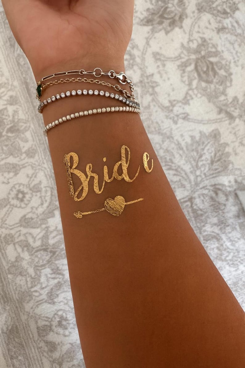 Goldene Team Bride und Bride Tattoos, Tattoos für Junggesellinnenabschied, Bachelorette Party und Hochzeit. Perfekte Accessoires für Braut und Team, glänzende goldene Tattoos für Fotoshooting, Partydeko und Brautparty. Einfache Anwendung, hautfreundlich und wasserfest – ideal als JGA Accessoires, Bridal Shower Tattoo Sticker, Hochzeitsdeko oder Geschenkidee für die Braut und ihre Mädels. JGA Zubehör, Klebetattoos