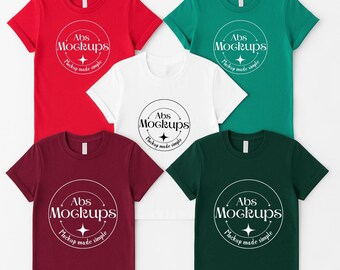 May include: A collection of five short-sleeved t-shirts in red, white, green, dark green, and burgundy. Each shirt features a circular logo with the text "Abs Mockups" and "Mockup made simple".