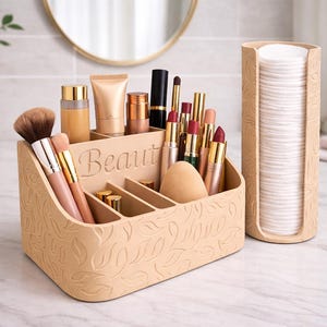 Könnte beinhalten: Beiger Kosmetik-Organizer mit dem Wort "Beauty" auf der Vorderseite, gefüllt mit Make-up-Pinseln, Lippenstiften und Hautpflegeprodukten. Rechts befindet sich ein passender Wattepadhalter. Der Organizer hat ein Blättermuster.
