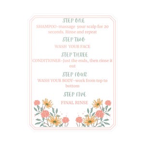 Op de afbeelding: Een witte sticker met een roze rand en bloemaccenten. De sticker bevat instructies voor een vijfstappenroutine: shampoo, gezicht wassen, conditioner, lichaam wassen en afspoelen. De tekst is lichtblauw.
