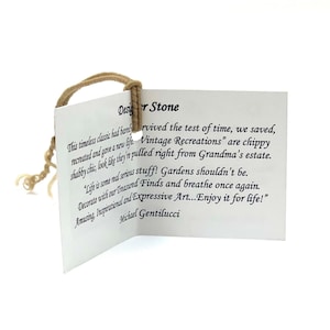 May include: A white rectangular paper tag with black printed text titled Designer Stone. The tag features a tan string loop attached through a hole at the top. The text includes the name Michael Gentilucci and descriptive sentences about vintage recreations.