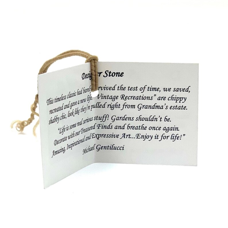 May include: A white rectangular paper tag with black printed text titled Designer Stone. The tag features a tan string loop attached through a hole at the top. The text includes the name Michael Gentilucci and descriptive sentences about vintage recreations.