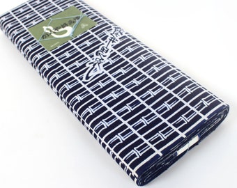 May include: A roll of white and navy blue fabric with a repeating pattern of vertical lines. The fabric has a label with the text "Shibori" in Japanese characters.
