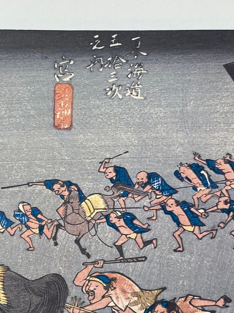 May include: Japanese woodblock print showing a procession of figures, some on foot and others on horseback, against a grey backdrop. The figures are dressed in blue and white clothing. Japanese text is visible in the upper left.