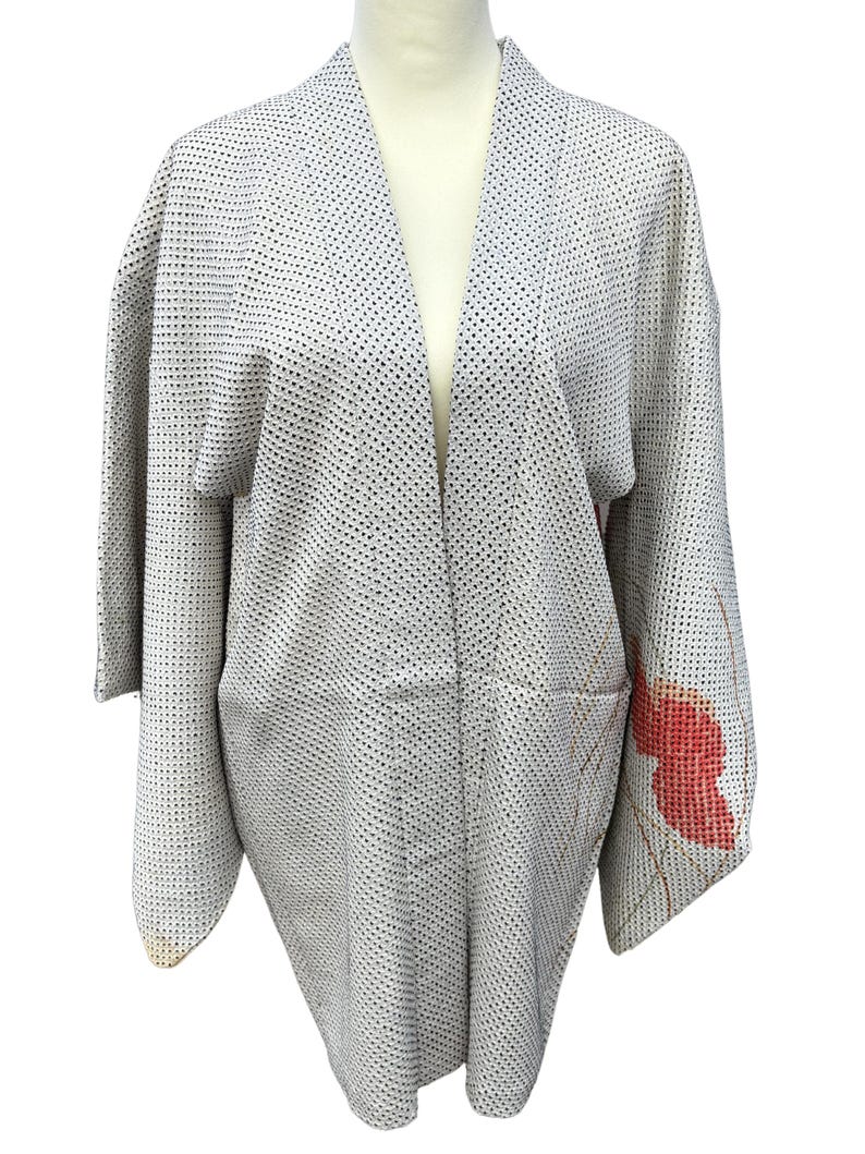 May include: A gray and white patterned kimono with a red and gold floral design on the right sleeve.