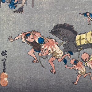 May include: Japanese woodblock print showing a busy street scene. People in traditional clothing are running alongside a horse-drawn cart. The artwork uses a muted colour palette with detailed linework, capturing a moment of action.