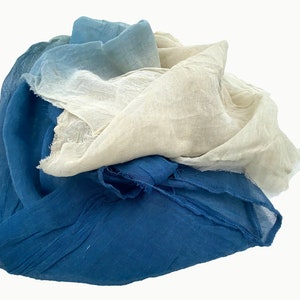 May include: A stack of three fabric squares in shades of blue, light blue, and white. The fabric is soft and has a slightly textured surface.