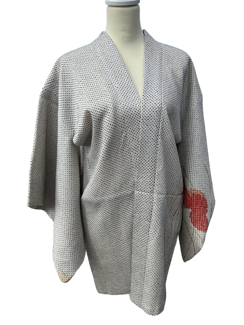 May include: A white Japanese kimono with a small black dot pattern and a red floral design on the sleeve.