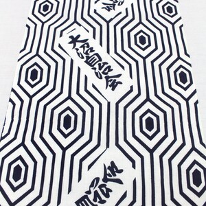 May include: White fabric with a black geometric pattern of hexagons and lines. The fabric has the Japanese word "大空" written in black on it.