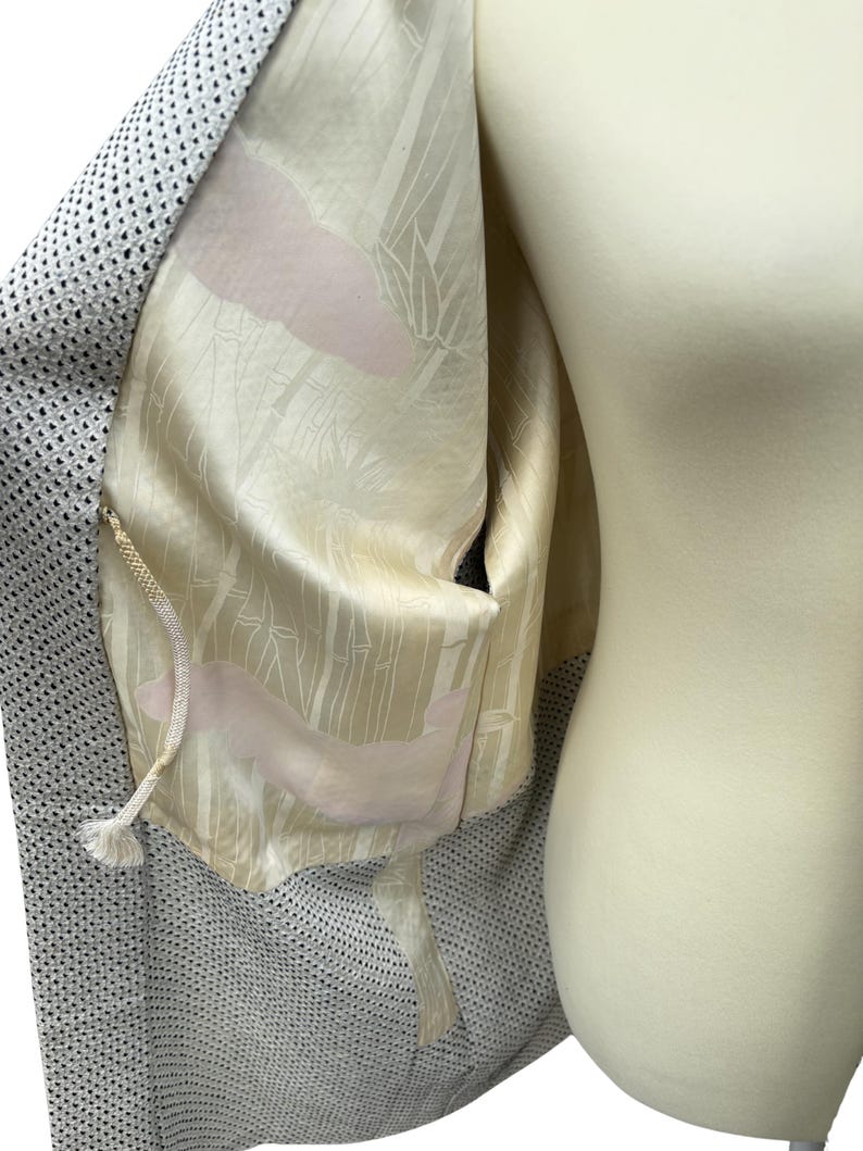 May include: A gray and white patterned kimono with a white lining featuring a pink and white bamboo design.