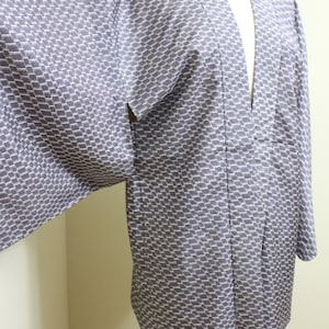 May include: A traditional Japanese kimono with a geometric pattern in shades of gray and white. The kimono is made of a lightweight fabric and has a relaxed fit.