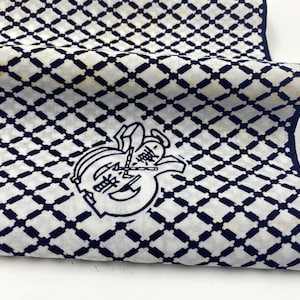 May include: A white cotton fabric with a navy blue diamond pattern. The fabric has a navy blue logo with Japanese characters and a halo.