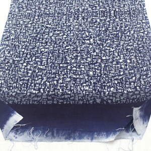 May include: A piece of blue fabric with a white pattern. The fabric has a frayed edge and is folded in half.