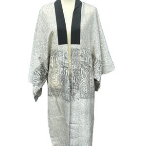 May include: A long, gray and white patterned kimono with a black collar. The kimono is open in the front and has a relaxed fit.