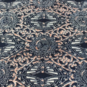 May include: A section of fabric with a repeating pattern of stylized flowers, butterflies, and swirling designs in cream, peach, and white against a navy blue background. The fabric has a slightly frayed edge.