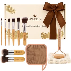 May include: A makeup brush set with a variety of brushes, a face roller, and a washcloth. The brushes have wooden handles and are arranged with a brown bow on a box. The box has the word SPARESS printed on it.