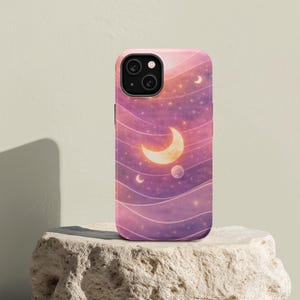Pode incluir: Capa de telemóvel com um design celestial. Apresenta uma lua crescente, estrelas e planetas num fundo ondulado rosa e roxo. A capa é feita de um material durável e foi concebida para proteger o telemóvel de riscos e impactos.
