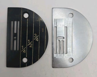 May include: Two semi-circular sewing machine needle plates. One plate is black with white markings for 1/4, 1/2, and 3/4 inch seam allowances and two screw holes. The other plate is silver-colored metal with a central needle slot and two screw holes.