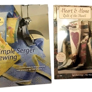 May include: Two instructional books for sewing and quilting. The left book is titled Simple Serger Sewing with 50 Projects, showing a serger machine and fabric. The right book is titled Heart & Home Quilt of the Month by Suzanne McNeill, featuring a quilt.
