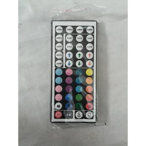 May include: A rectangular black remote control with numerous buttons and a variety of colors. The buttons include options for color selection, brightness, and special effects like flash and fade. The remote is packaged in a clear plastic bag.