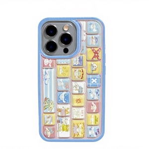 May include: A light blue phone case with a colorful, whimsical design. The case features a grid of small, square illustrations in pastel colors, including bunnies and other cute characters. The case has a blue border and a camera cutout.