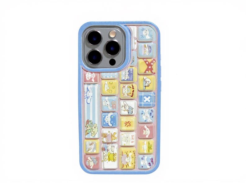 May include: A light blue phone case with a colorful, whimsical design. The case features a grid of small, square illustrations in pastel colors, including bunnies and other cute characters. The case has a blue border and a camera cutout.