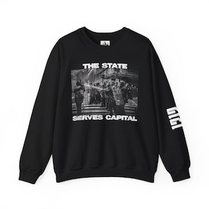 Könnte beinhalten: Schwarzes Sweatshirt mit einem schwarz-weiß Grafikdruck einer Straßenszene mit Polizei und dem Text "THE STATE SERVES CAPITAL". Auf dem rechten Ärmel steht in Weiß "1919".