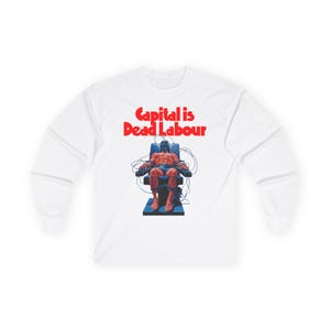 May include: White long-sleeve shirt with the red text "Capital is Dead Labour." The graphic depicts a person strapped to a chair with wires. The person is shirtless and has a blue head covering.