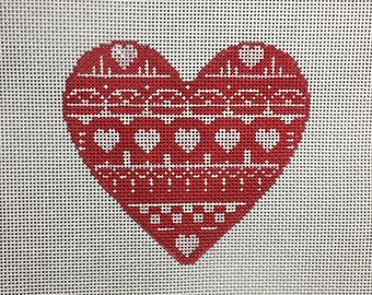 May include: Red heart-shaped canvas with a white and red geometric pattern. The heart is stitched with white thread.